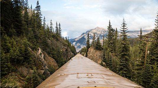 View of the Canadian Rocky mountains from on top of a train.