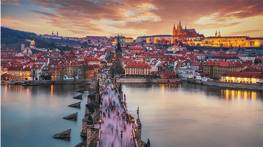 Aerial view of Charles Bridge and Prague at sunset.