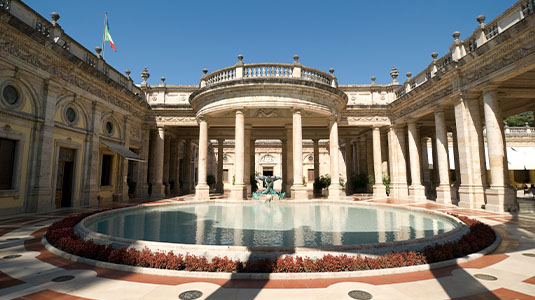 Spa entrance with marble archway and reflecting pool.