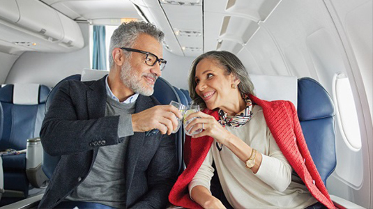 Couple on a plane clinking glasses