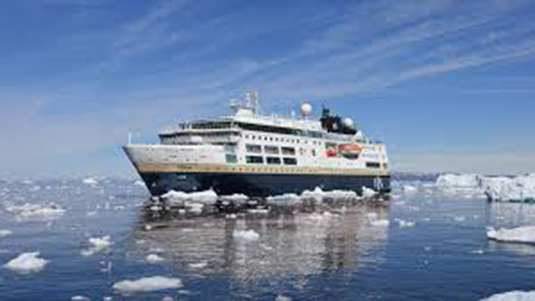 HX Expeditions ship on water surrounded by small floating ice.