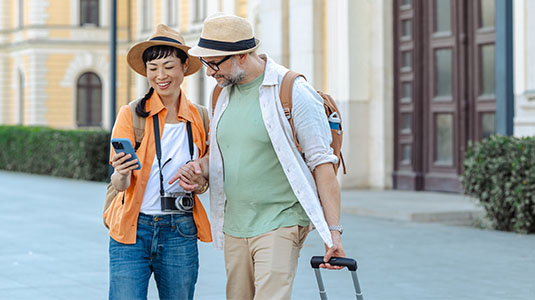 A couple looking at directions on a phone while walking