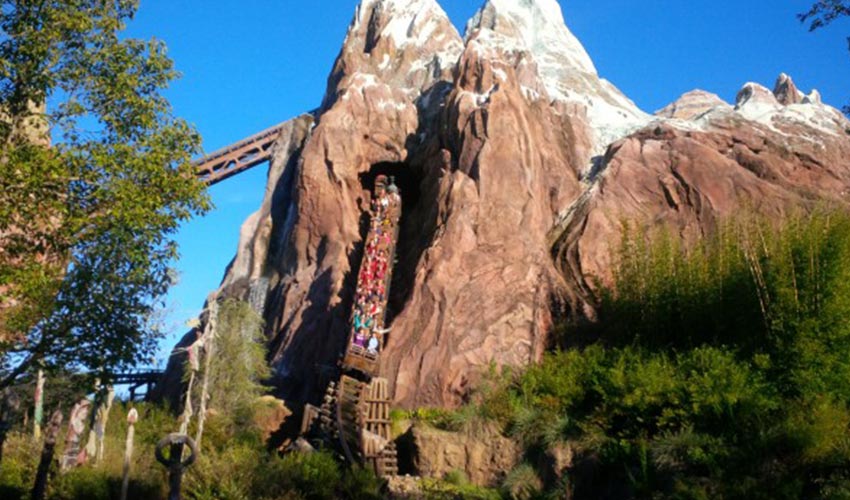 A roller coaster ride going through a mountain at Disney.