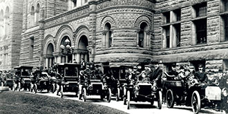 A black and white photo from 1903 showing motorists gathering at Queens Park